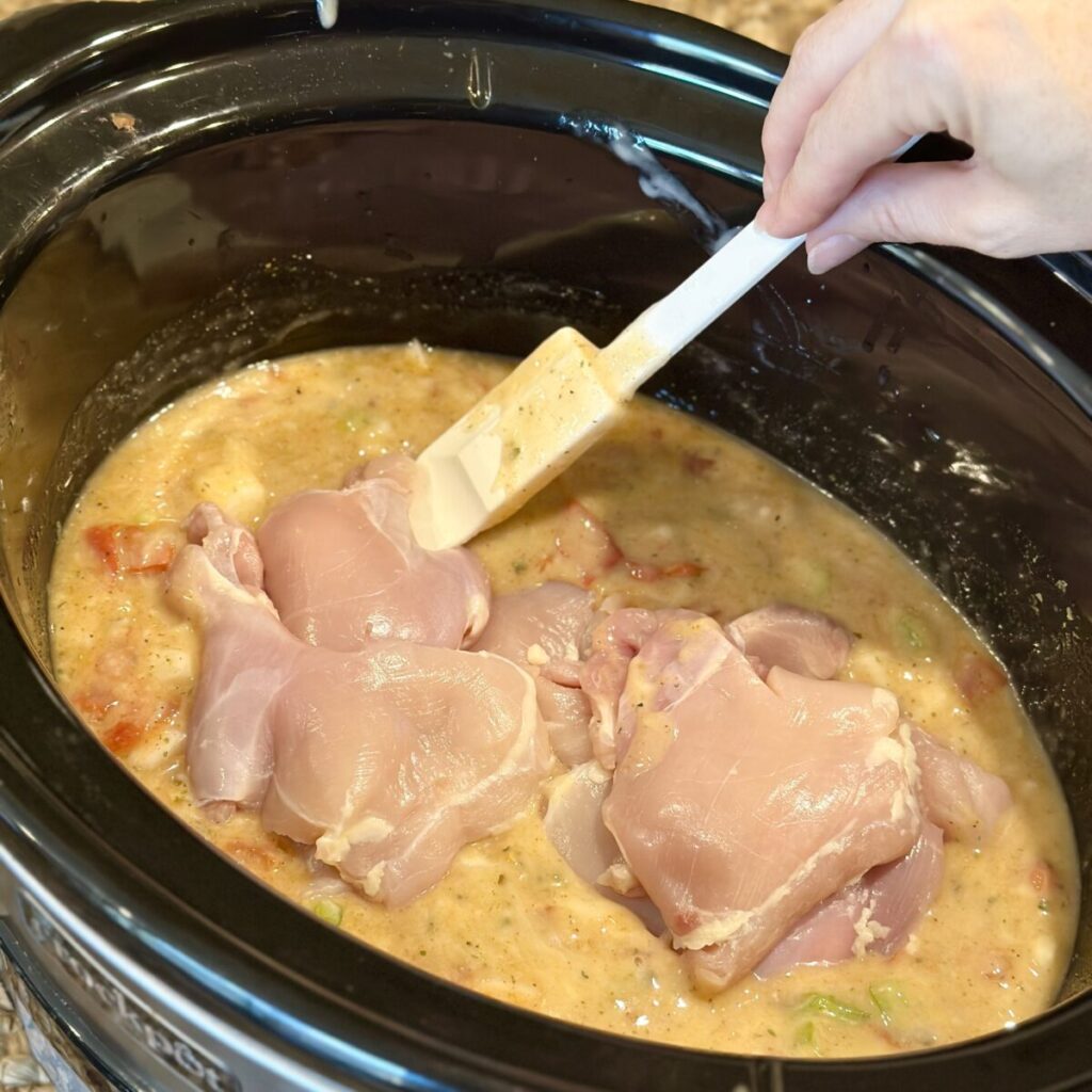 Adding chicken to a crockpot.