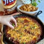 Adding green onions to the top of cornbread chili pie.