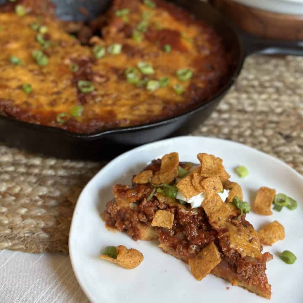 A slice of cornbread chili pie on a saucer.