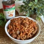 A bowl of homemade spaghettios with a can of spaghettios next to it.