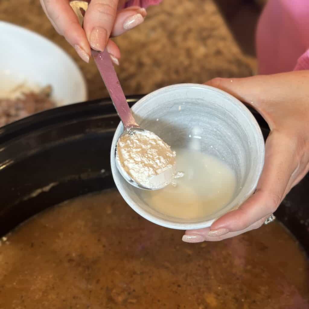 Making a cornstarch slurry in a small bowl.