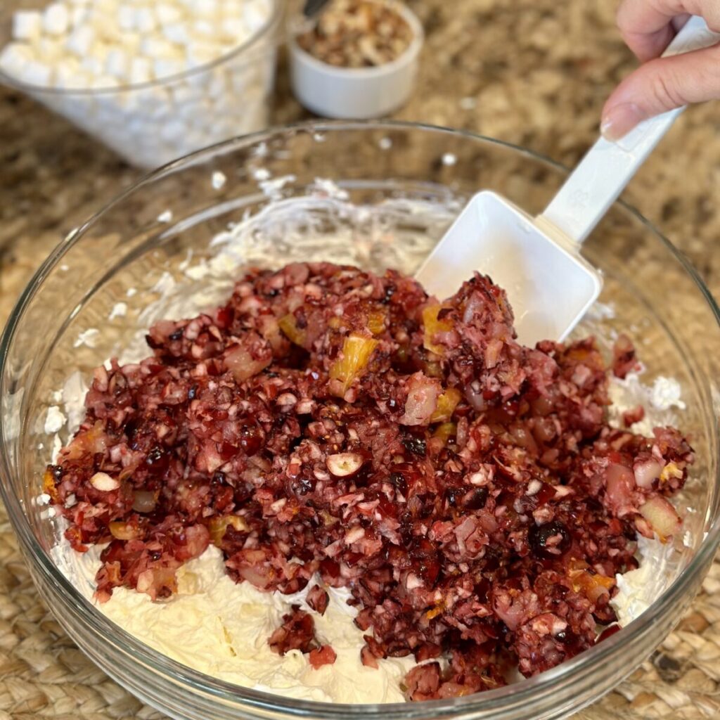 Folding chopped cranberries in a bowl.