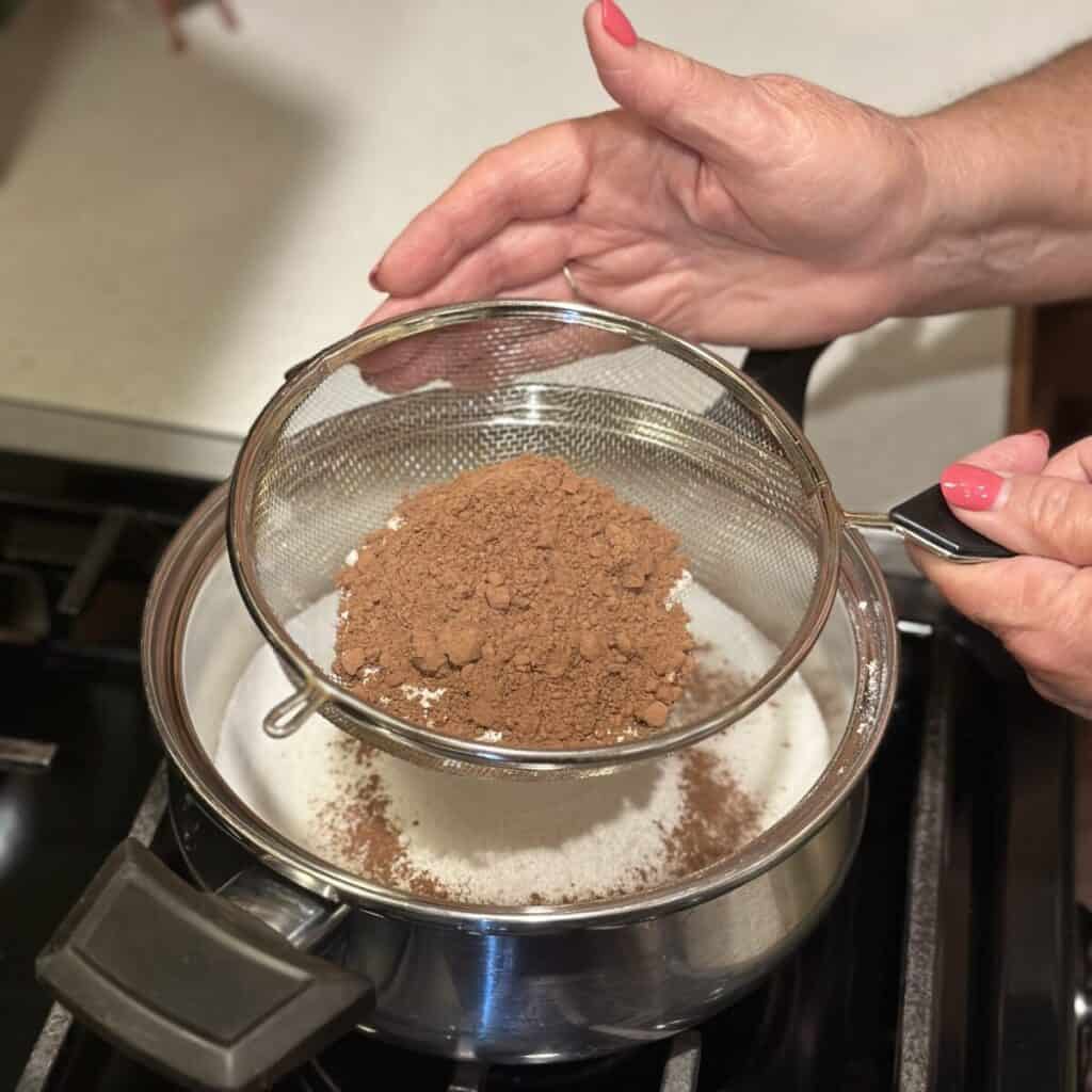 Sifting cocoa in a pan.