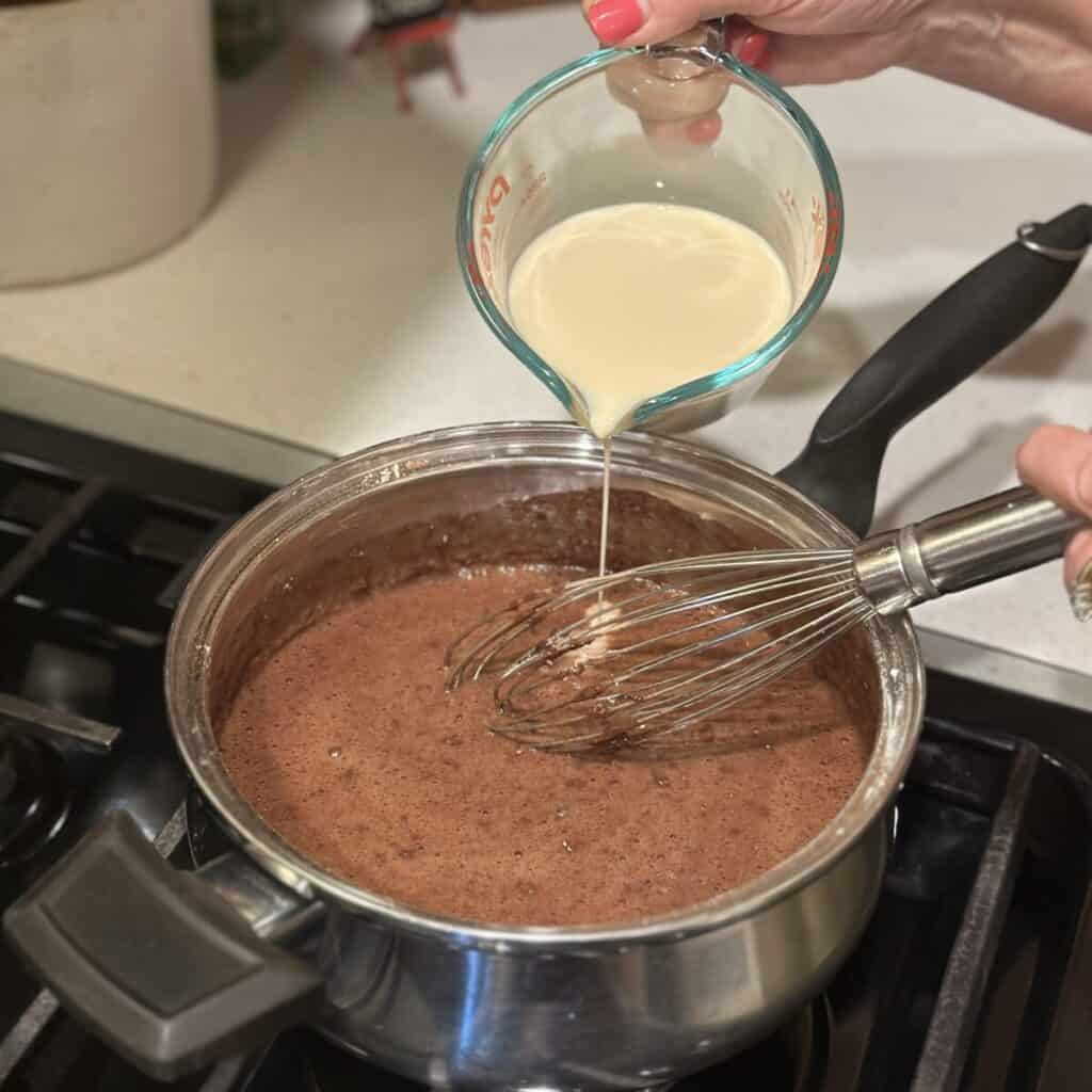 Adding milk to a pan.