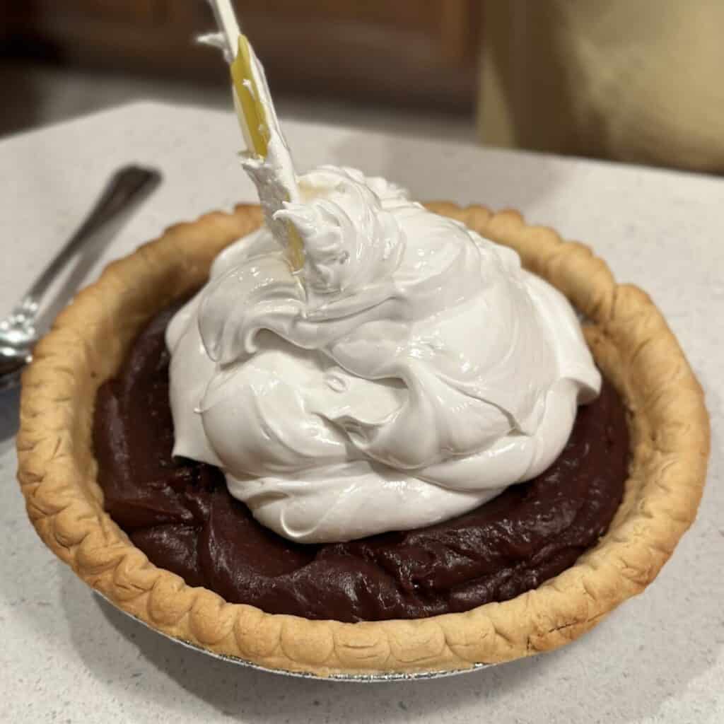 Spreading meringue on a chocolate pie.