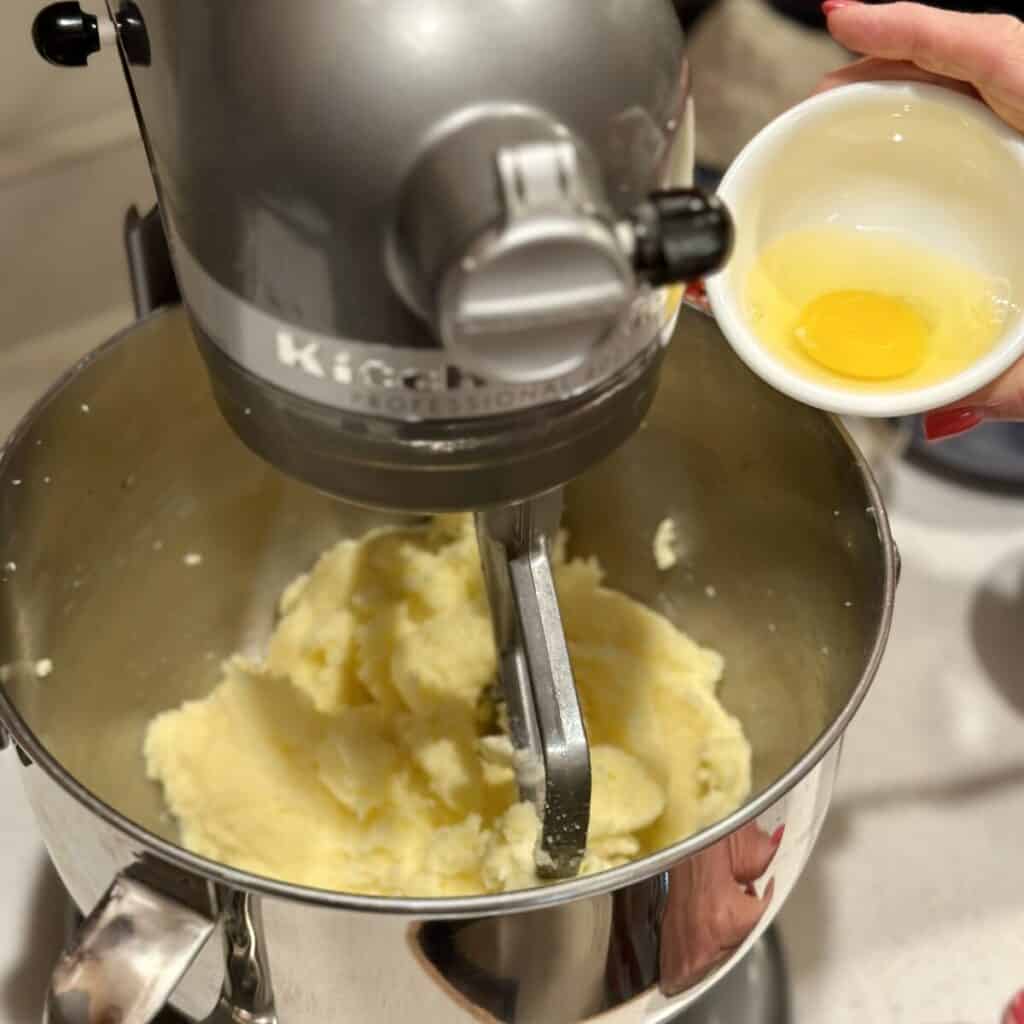 Adding eggs to pound cake batter.