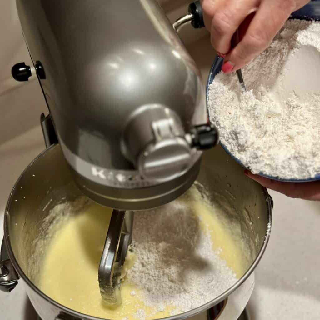 Adding flour to pound cake batter.