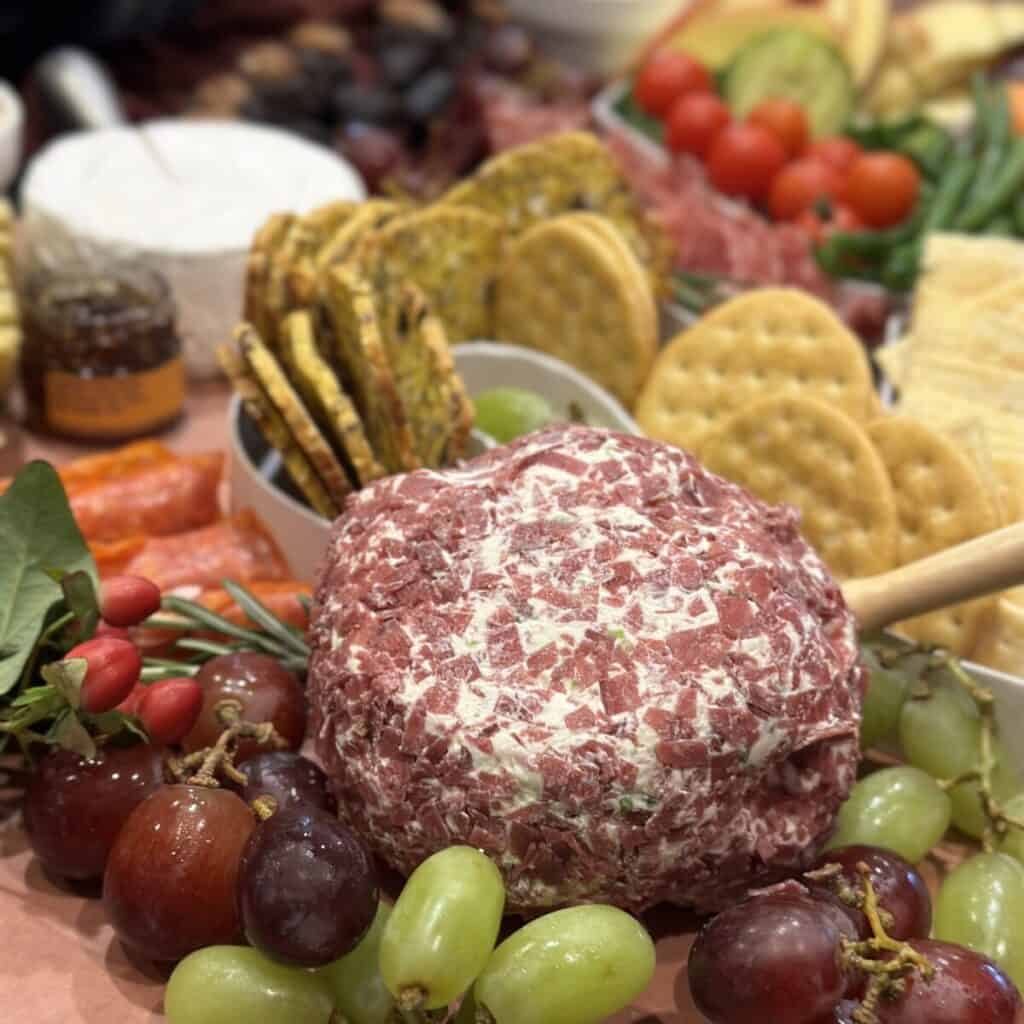 A cheeseball on a charcuterie board.