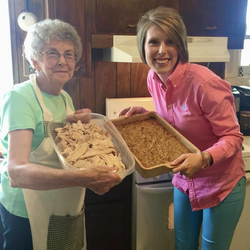 A picture of mamaw and Laura holding turkey and dressing.