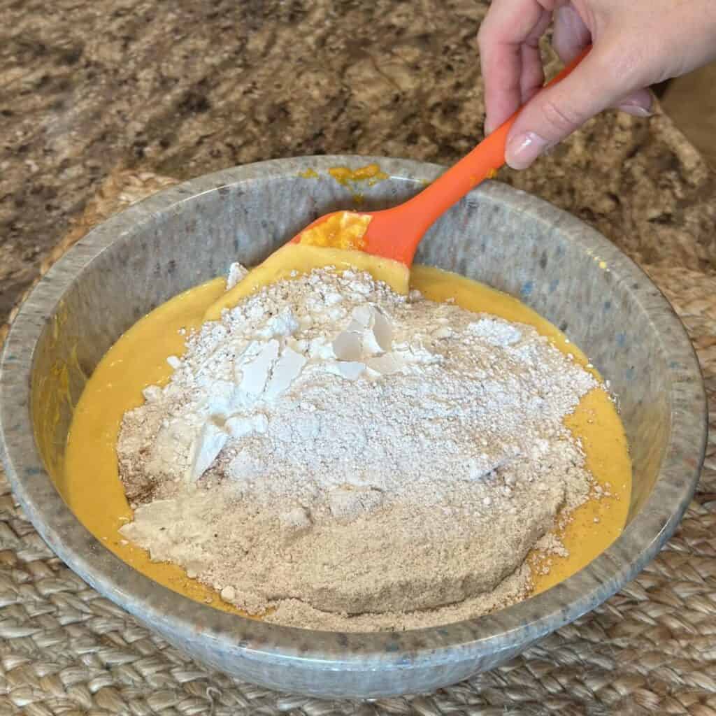 Mixing the dry and wet ingredients for pumpkin coffee cake.