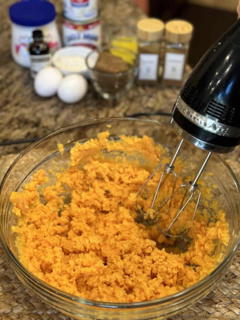 Whipping sweet potatoes in a bowl.