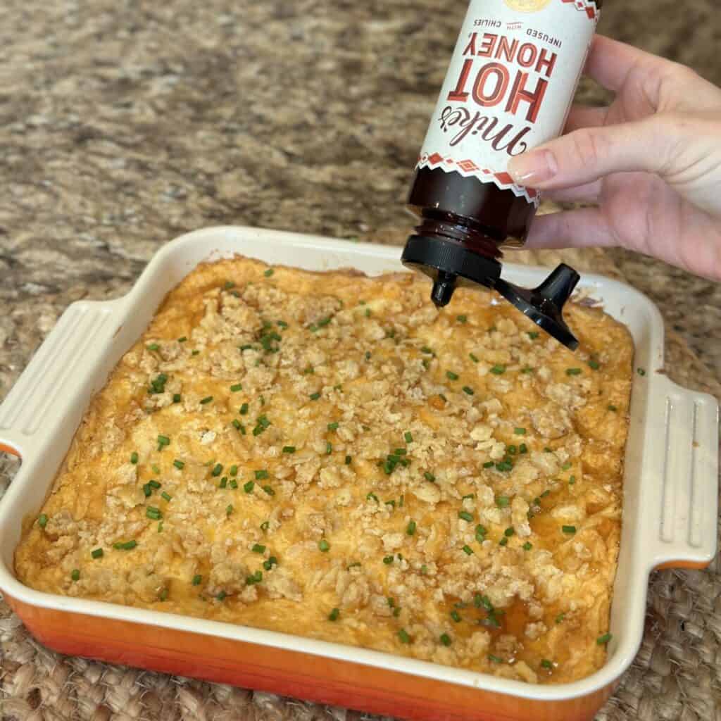 Garnishing the top of a Nashville hot chicken dip.