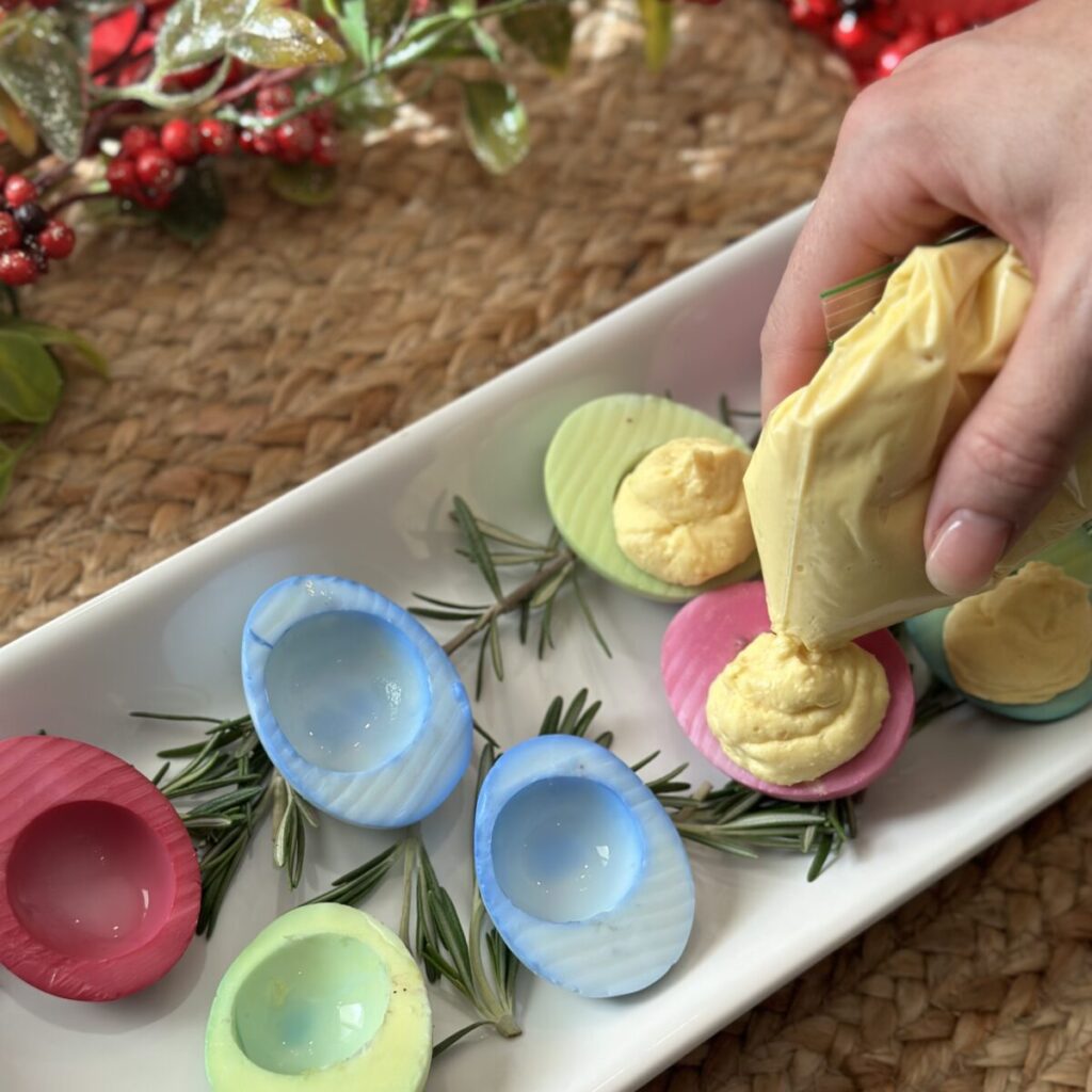 Filling egg whites with egg yolk mixture.