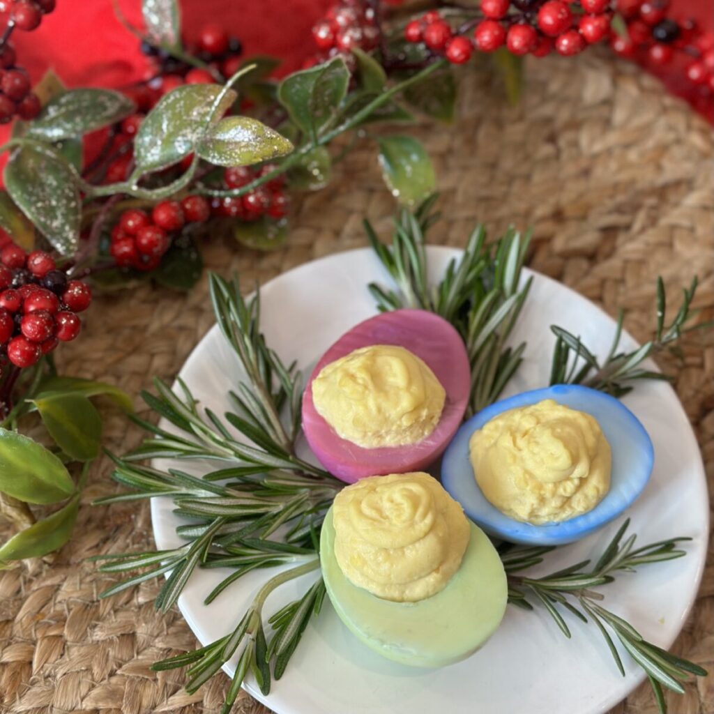 Colored deviled eggs on a saucer.