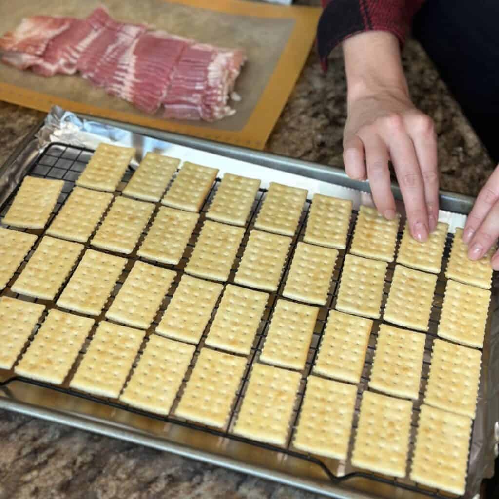 Laying crackers on a sheet pan.