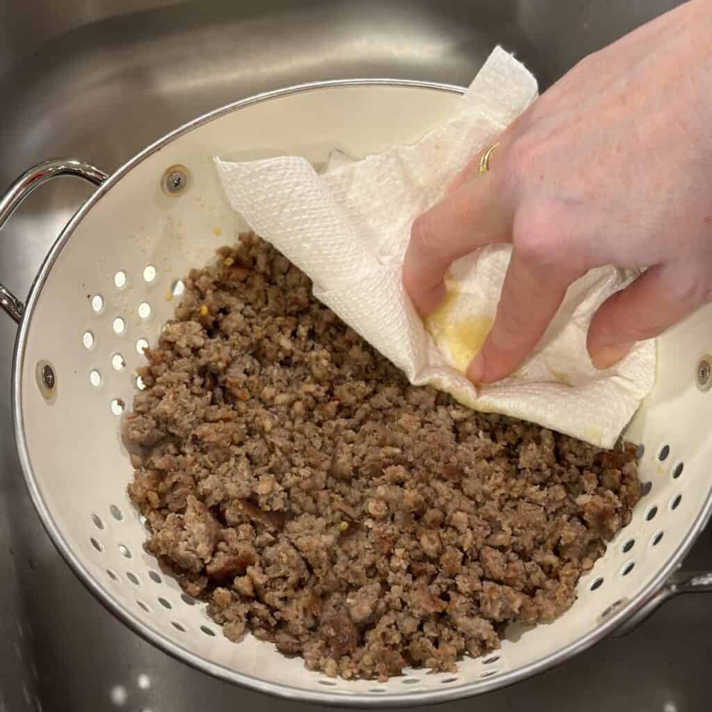 Draining grease from sausage in a colander.