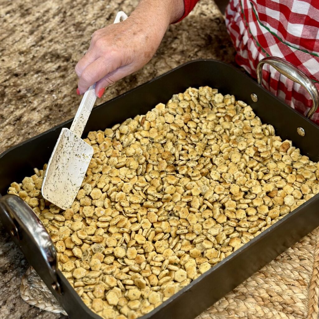 Spreading crackers in a roasting pan.